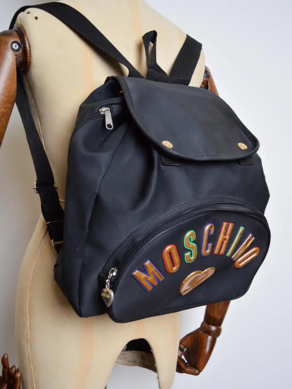 1990's Vintage Moschino Black Backpack with Multicolor Lettering and Gold Heart
